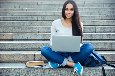 Girl working on laptop connected to cloud servies